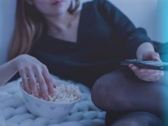 Snap test: We tasted five microwave popcorns; this one came out tops A woman having popcorn and watching TV.