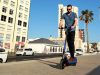 NIU KQi3 Sport Electric Kick Scooter – Review A young man riding an electric kick scooter on Strand promenade, South Africa