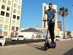 NIU KQi3 Sport Electric Kick Scooter – Review A young man riding an electric kick scooter on Strand promenade, South Africa