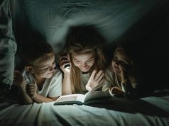 Eurolux Rechargeable 3W LED Emergency Light – Review A women holding a torch, reading to a boy and girl while under a sheet.