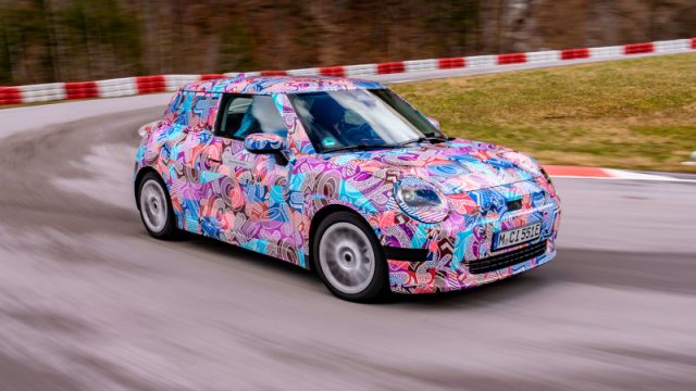 The 2024 electric Mini Cooper, in pink camo, going round the track.